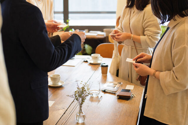 カフェでの交流会で名刺交換をする様子